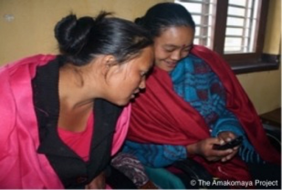 Two women in Nepal looking at pregnancy content on a mobile phone